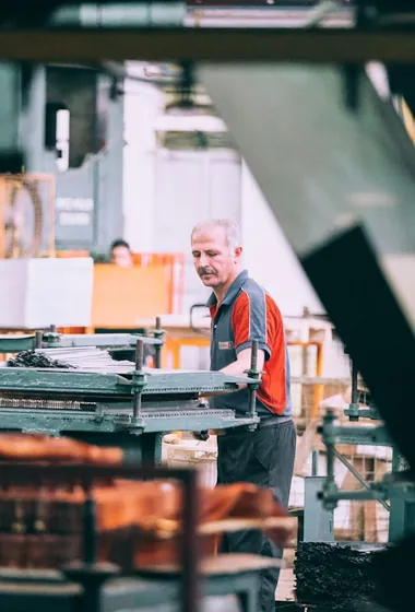 A machine operator at a press on a factory floor