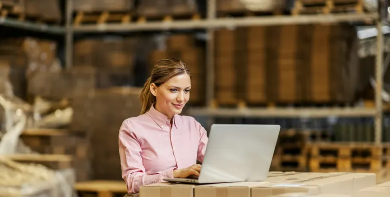 A buyer ordering parts on a laptop in a warehouse