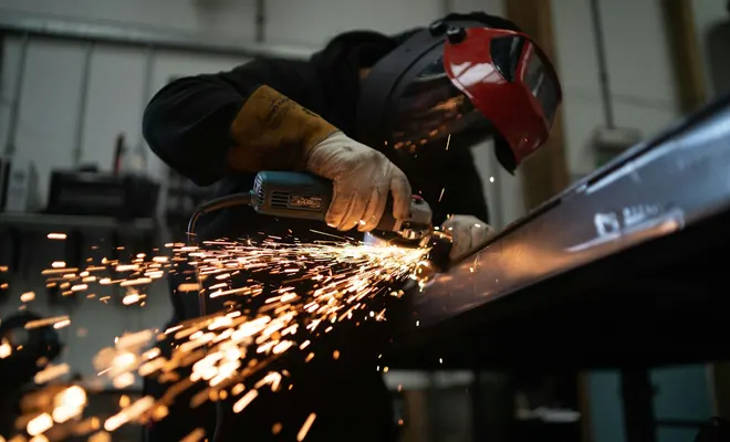 A welder cutting steel in a shower of sparks